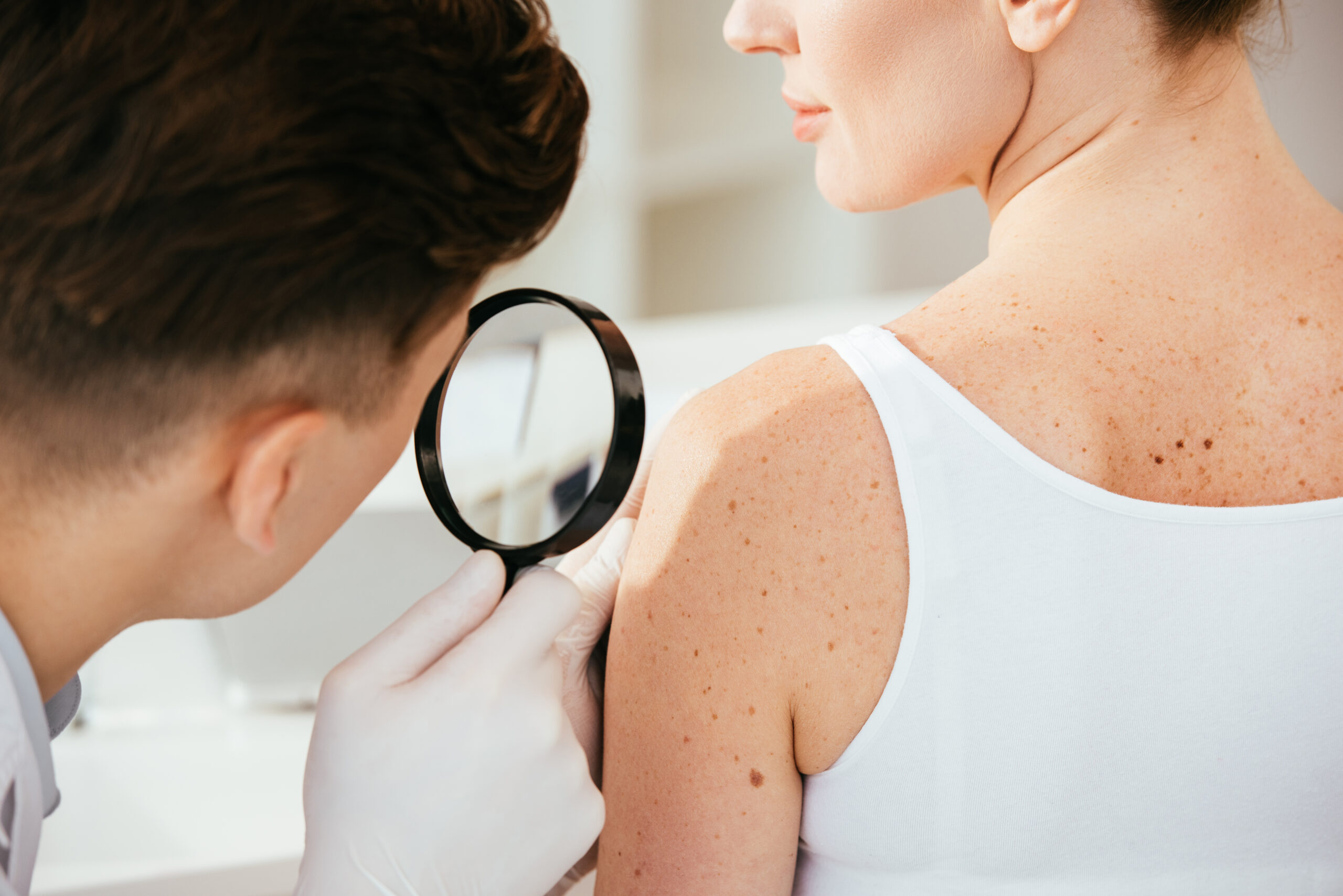 Dermatologist using dermoscopy for skin cancer screening at Couture Dermatology and Laser